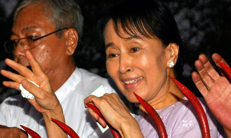 Aung San Suu Kyi waves to supporters gathered outside her house after her
