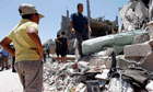 People stand at a house, which was damaged by coalition air strikes