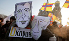 Demonstrators wearing mock mask depicting Mikhail Prokhorov and Putin