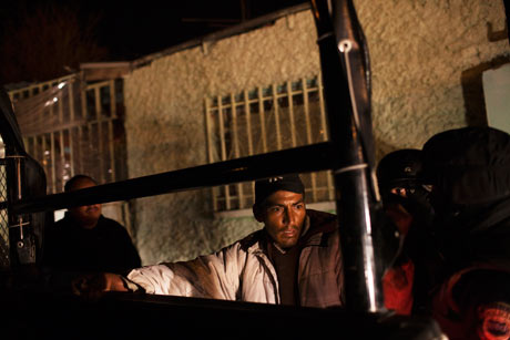 Police in Ciudad  Juárez frisk a man during a security sweep