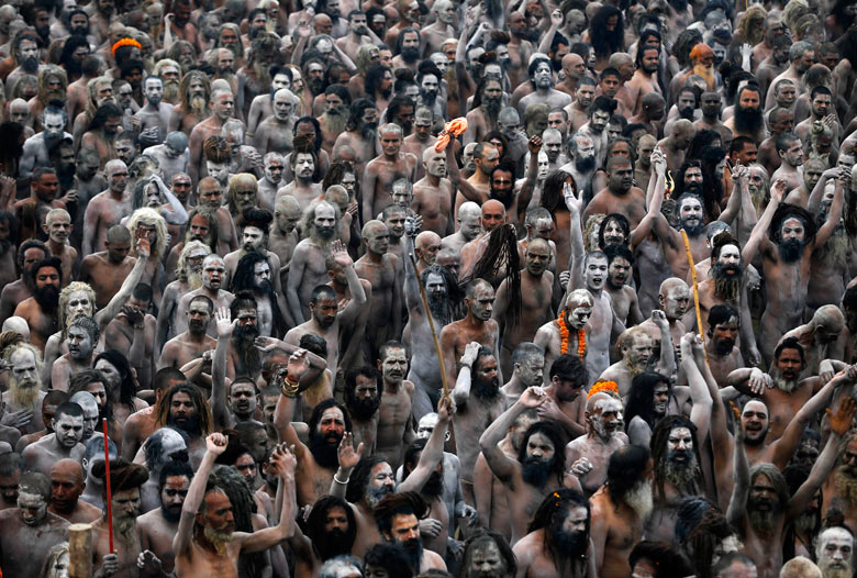 Naga Sadhus, or Hindu naked holy men, walk in procession after bathing at Sangam