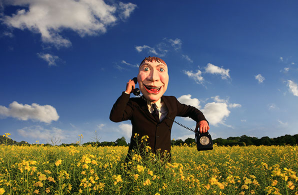 Stock category : Man wearing a Happy Mask in field of rapeseed, by Ben Ryan.