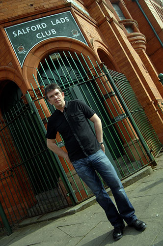   Manchester Music Tour: Mike Joyce poses outside Salford Lads Club.