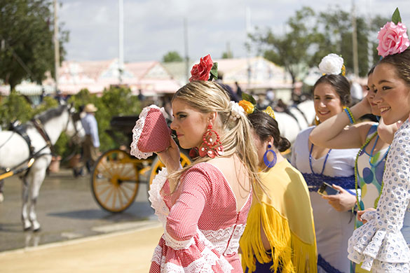 Photography masterclass: A crowd of party goers in Seville watch some horse-drawn carriages