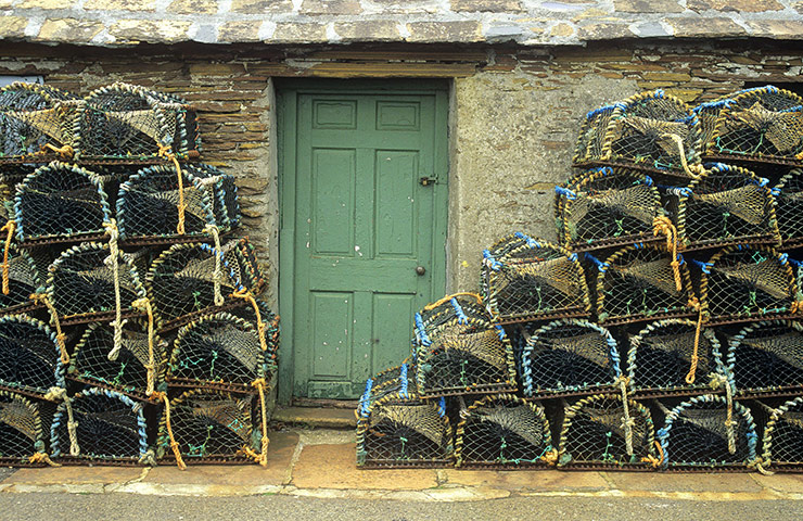 Visit Orkney: Lobster pots piled outside a doorway in Stromness.