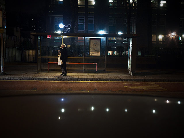 Panasonic - Nocturnal: Man standing at a bus stop on Hackney Road in London