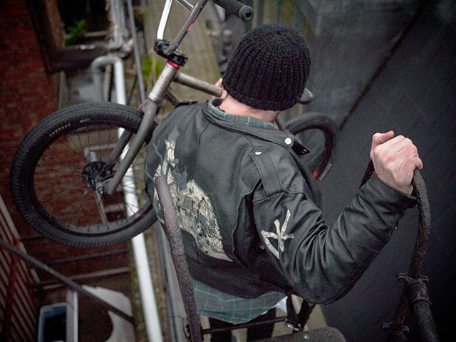 Panasonic rooftop rider: A biker lifts his bike down a fire escape