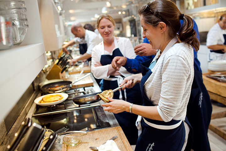 Enjoy England Daylesford: A woman attempts to flip a pancake at the cookery school