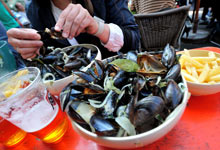 A person eats mussels and French fries during the annual Braderie de Lille