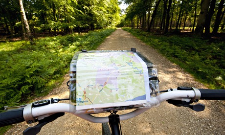 VE cycling: Cyclist With Map Following A Cycle Route Around Brockenhurst, New Forest National Park