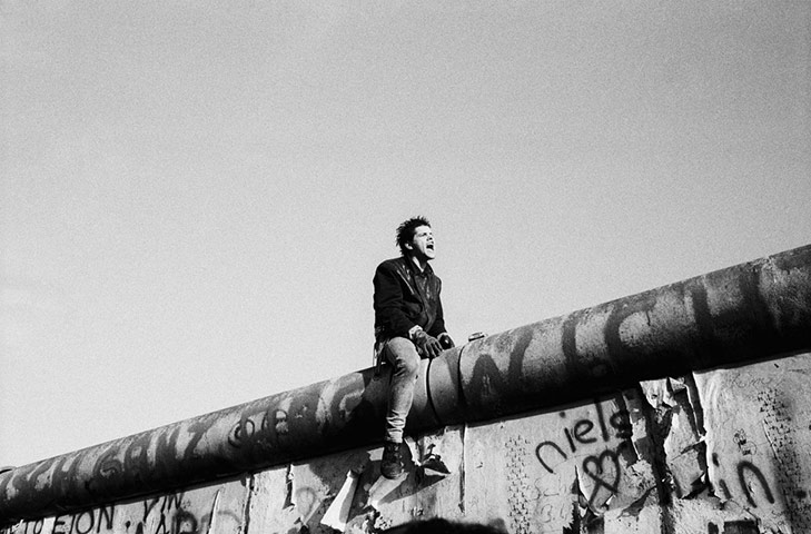 Europe 1945-2011: A young man sits atop the Berlin Wall