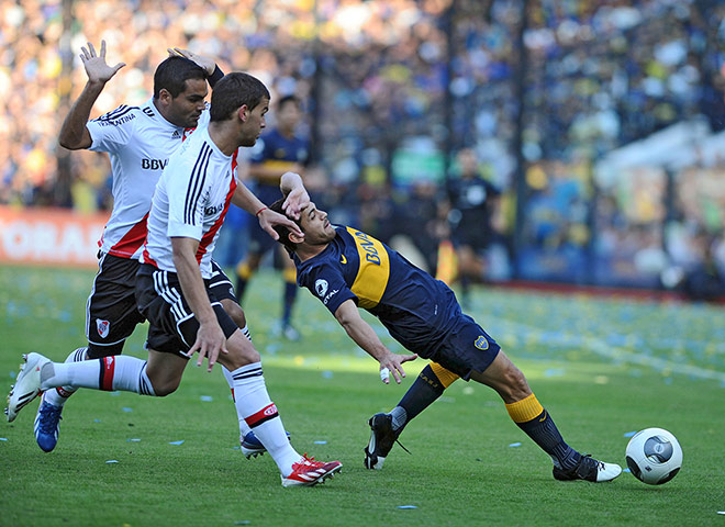 Superclasico: Lautaro Acosta of Boca Juniors struggles for the ball with Leandro Gonz