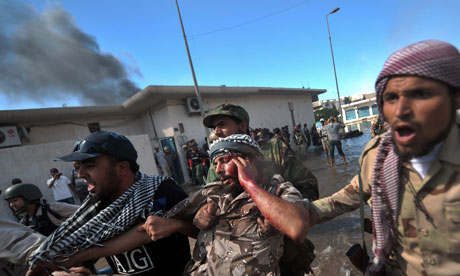 NTC fighters evacuate a wounded comrade during battles in Sirte, Libya