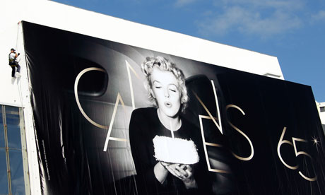 An employee fixes a giant poster of Marilyn Monroe on the facade of the Cannes film festival palace