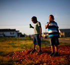 Boys stand on an empty lot where a house once stood in Joplin, Missouri