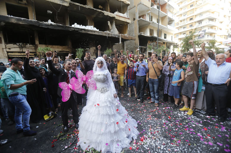 A Lebanese couple celebrate their marriage at the site of a car bomb explosion which killed at least