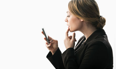 A woman using a smartphone as mirror 