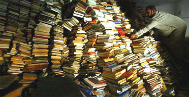 An assistant imam checks books taken to a mosque for safekeeping after reportedly being looted from Iraq's national library after the fall of Baghdad