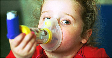 A young asthma sufferer uses her inhaler