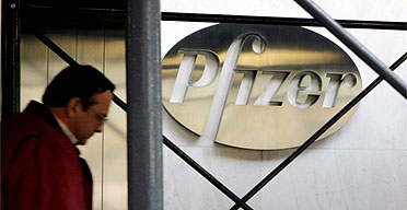 A pedestrian walks past the Pfizer Inc. headquarters building in New York