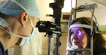 A consultant examines a patient's eye