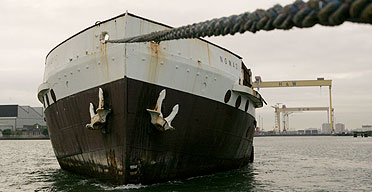 The SS Nomadic, the tender ship to the Titanic, is towed to Barnetts Quay in Belfast, where it will undergo repairs.