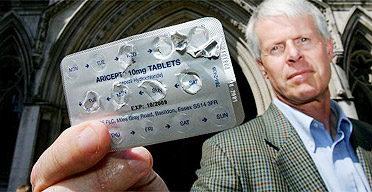 John Stevenson poses outside the High Court with a packet of Aricept following a court judgement on NHS restrictions on Alzheimer's drugs