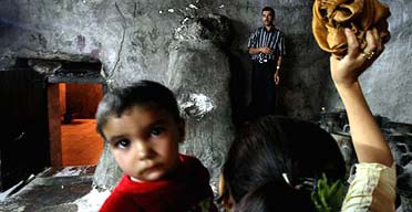 A Yezidi Iraqi throws a cloth at jars of oil in order to make a wish at a temple in Lalish