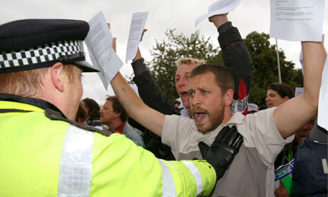 Climate change protestors are held back by police officers