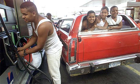 A man fills up his car at a petrol station in Caracas