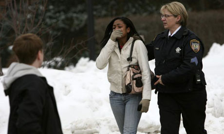 An officer leads a woman from Cole Hall at Northern Illinois university