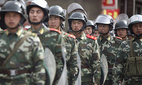 Chinese soldiers in riot gear patrol the city of Kangding in Sichuan province