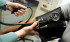 A doctor reads a blood pressure gauge during an examination of a patient. Photograph: Joe Raedle/Getty Images