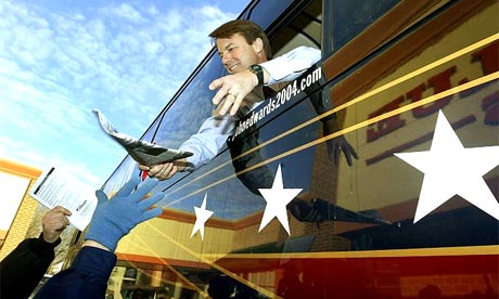 Former Democratic presidential candidate Senator John Edwards hands back an autographed newspaper while campaigning in Des Moines, Iowa