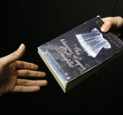 A person hands a book to another