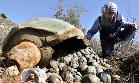 A Mines Advisory Group technician inspects a cluster bomb unit in the Lebanese village of Ouazaiyeh