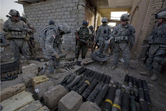 US soldiers remove mortars and IEDs (improvised explosive devices) disguised as concrete blocks from a Mahdi army cache uncovered with the Iraqi army