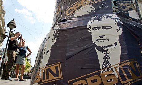 A pedestrian takes pictures of posters supporting the war crimes suspect Radovan Karadzic in downtown Belgrade