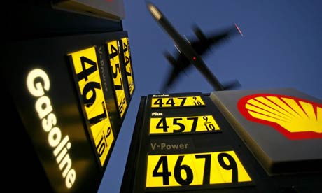 A plane flying over a petrol station