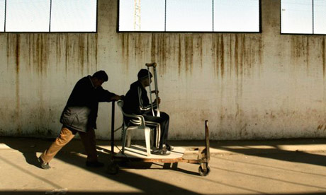 A porter pushes a 15-year-old Palestinian cancer patient through the Erez crossing between the Gaza Strip and Israel