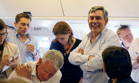 Gordon Brown jokes with the press on board to Beijing