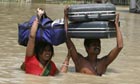 An Indian couple attempt to rescue what they can during the floods that have hit the Bihar state