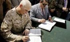 Major John Kelly and Anbar governor Mamun Sami Rasheed sign handover documents in Ramadi yesterday