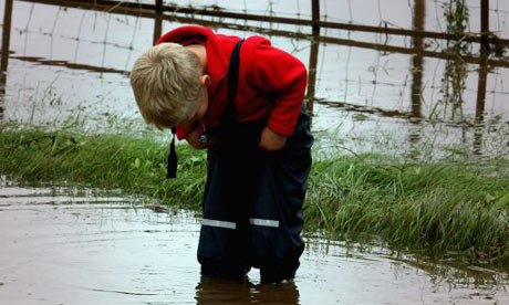 A boy plays in water on a flooded road near Tenbury Wells in Worcestershire
