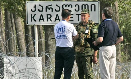 A Russian soldier, centre, talks to representatives of a UN humanitarian convoy at the Russian checkpoint at Karaleti, Georgia, before the convoy was turned away