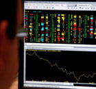 A city worker looks at the FTSE 100 index