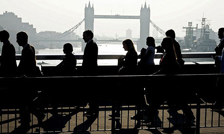 City workers walk across London Bridge on their way to their offices in the financial centre in the City of London