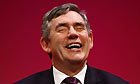Gordon Brown laughs as he listens to speeches