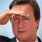Leader of the Conservative Party David Cameron shields his eyes from the sun