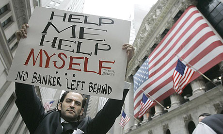 A protestor holds a sign as he marches past the New York Stock Exchange during a rally against the Wall Street bail-out.